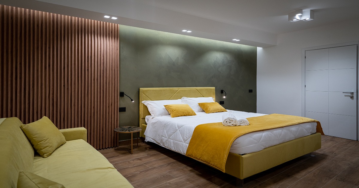 La Deluxe Room è la camera perfetta per coloro che cercano una sistemazione confortevole e spaziosa durante il loro soggiorno. Questa camera offre un'esperienza di soggiorno indimenticabile grazie ai suoi numerosi comfort. La Deluxe Room vanta un arredamento elegante e moderno, con tonalità calde e morbide, illuminazioni che creano un'atmosfera intima e romantica. La camera è dotata di un letto ultra confortevole, con lenzuola di alta qualità e cuscini soffici che garantiscono un sonno riposante. Inoltre, la Deluxe Room dispone di un comodissimo divano, dove gli ospiti possono rilassarsi e godersi un drink o uno snack. La camera è dotata di aria condizionata, Smart-Tv con accesso gratuito alle principali piattaforme di streaming (Netflix, Prime Video, TimVision), filodiffusione, connessione Wi-Fi gratuita, mini-bar, cassaforte, macchinetta del caffè, asciugacapelli, set di cortesia e specchio trucco.